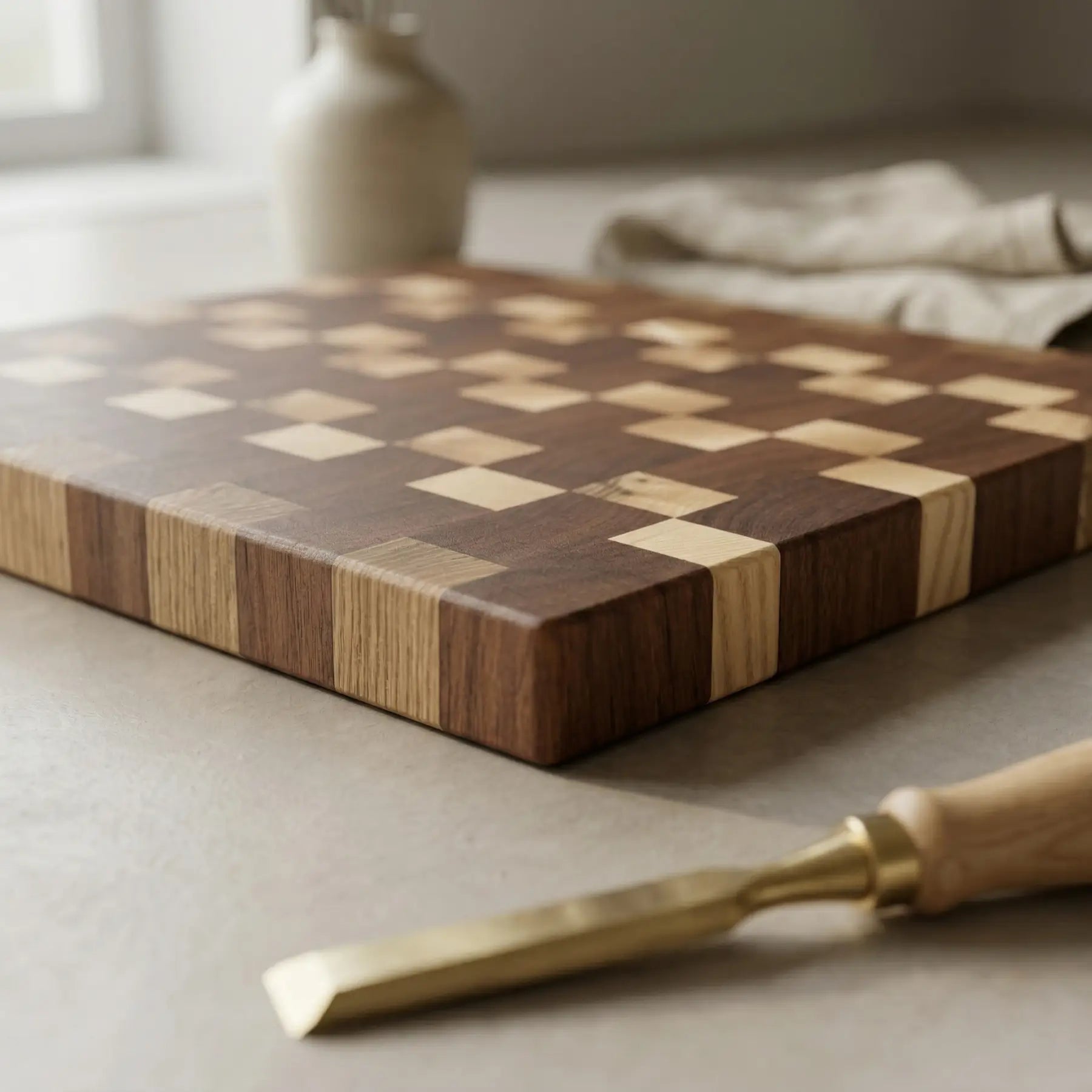 Solid sapele and ash chopping block 335x310 mm resting on a light countertop with culinary tools.