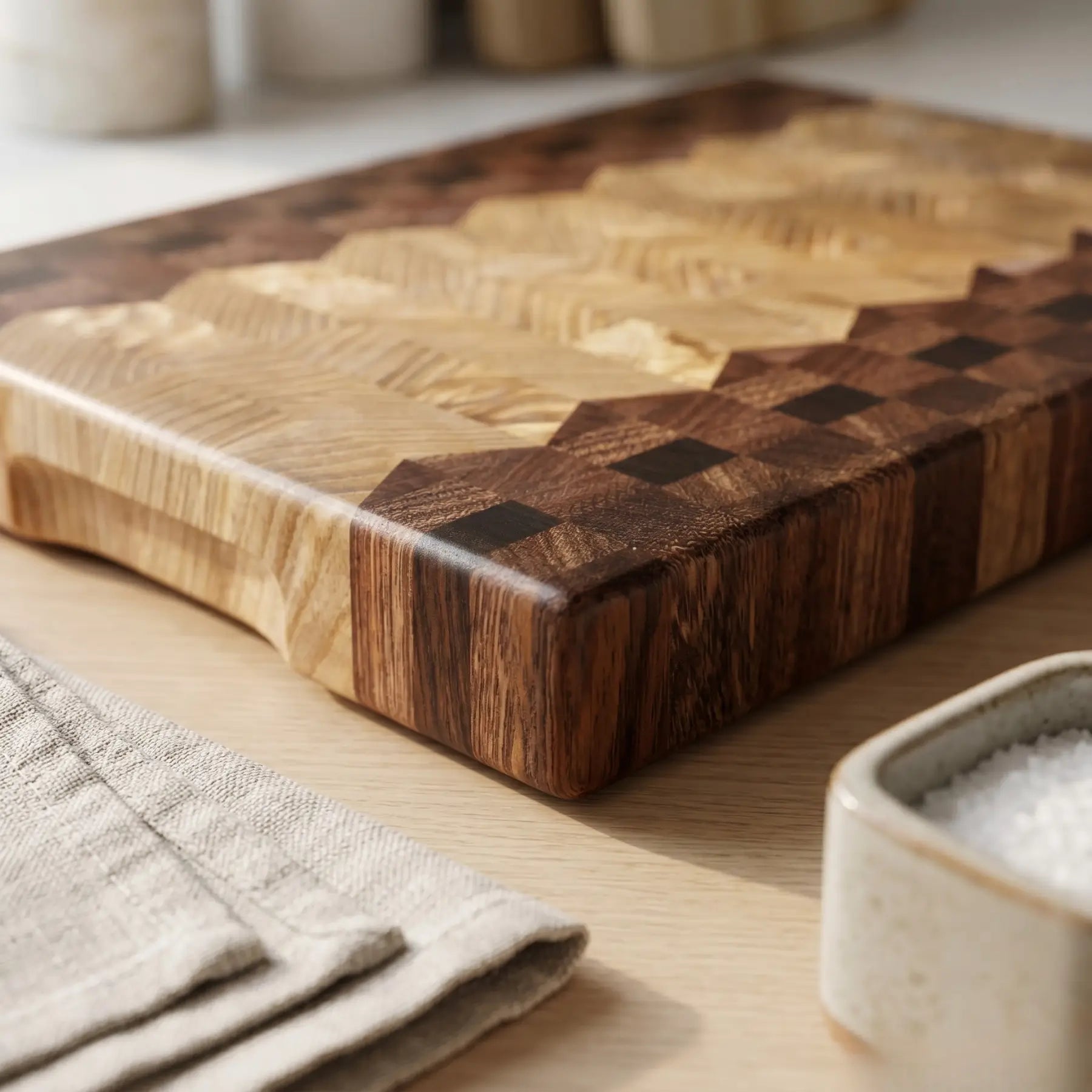 Deep sucupira wood grain beside pale ash on handmade end-grain cutting board