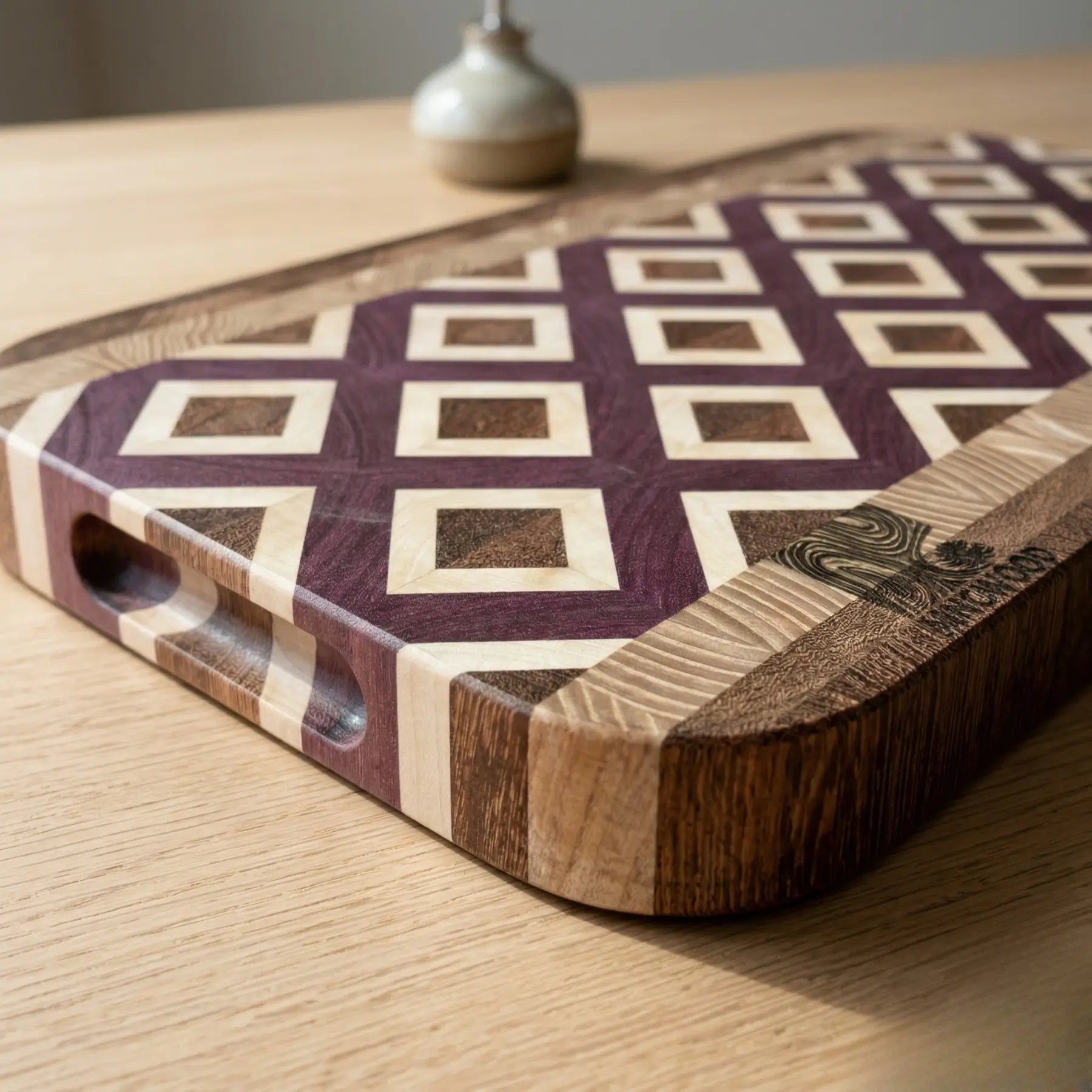 Thick 1.57 inch end grain chopping board made from four wood types next to olive oil and sea salt.